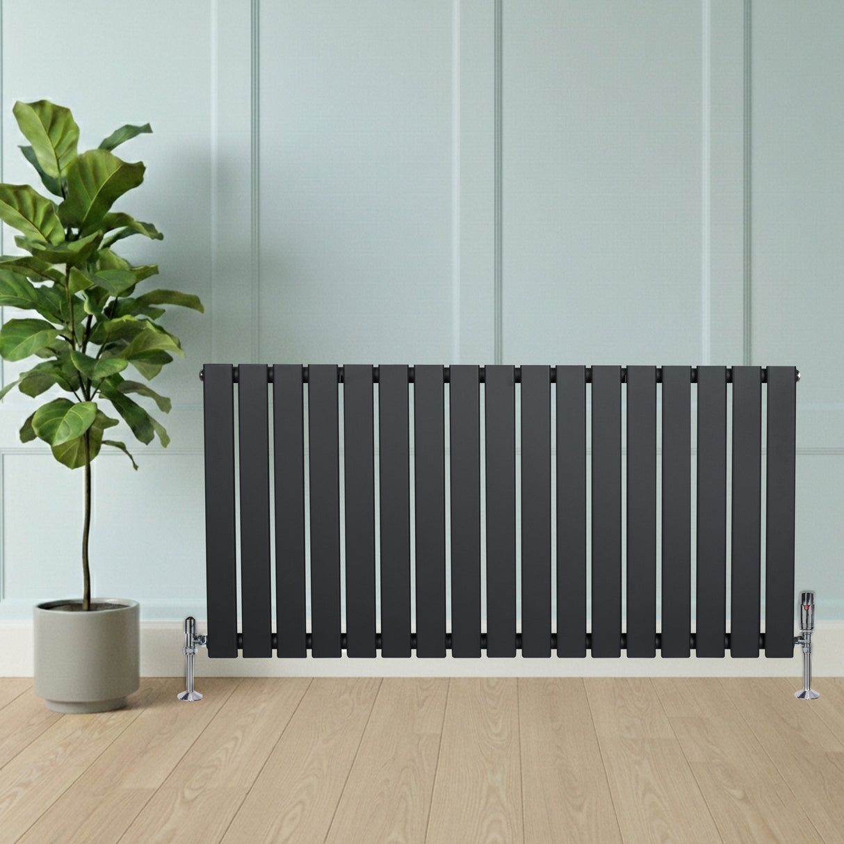 Radiatore piatto monocolonna grigio antracite con valvole, design elegante e lineare, posizionato accanto a una pianta in vaso