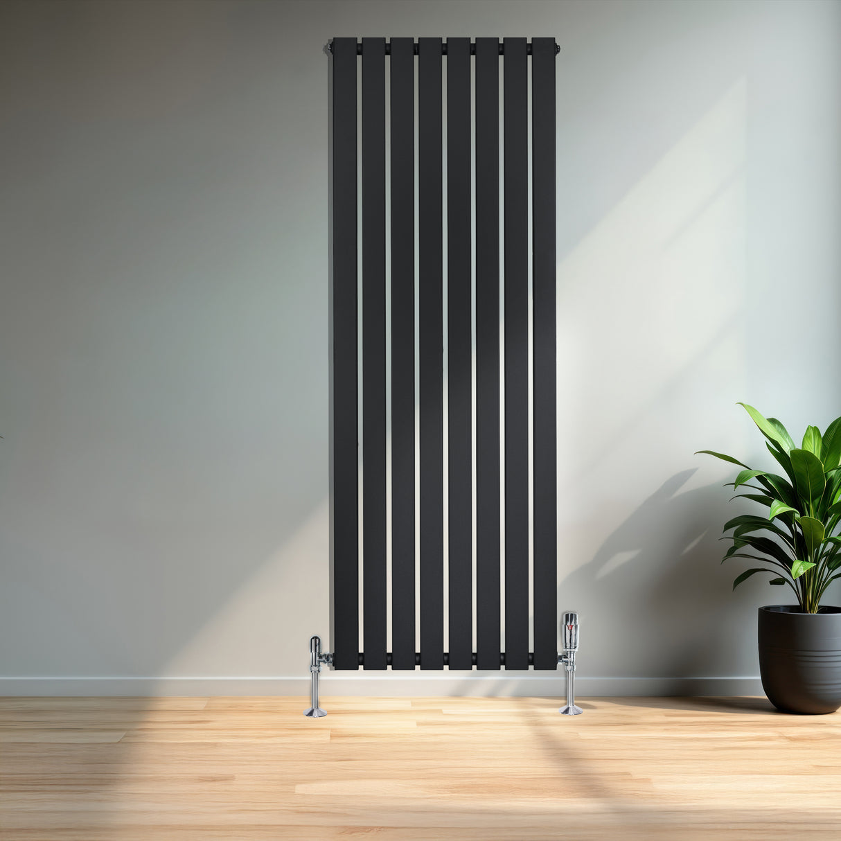 Radiatore piatto monocolonna nero con finitura liscia, dimensioni 1600 x 560 mm, installato in un ambiente moderno e luminoso