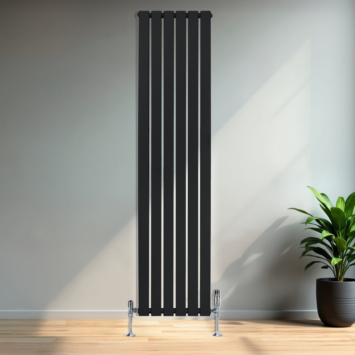 Radiatore piatto monocolonna nero, 1800 x 420 mm, con finitura liscia e valvole, posizionato su una parete in un ambiente moderno e luminoso