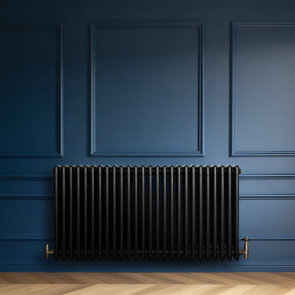 Radiatore tradizionale orizzontale a 4 colonne, finitura nera lucida, installato su parete blu scuro con pavimento in legno chiaro