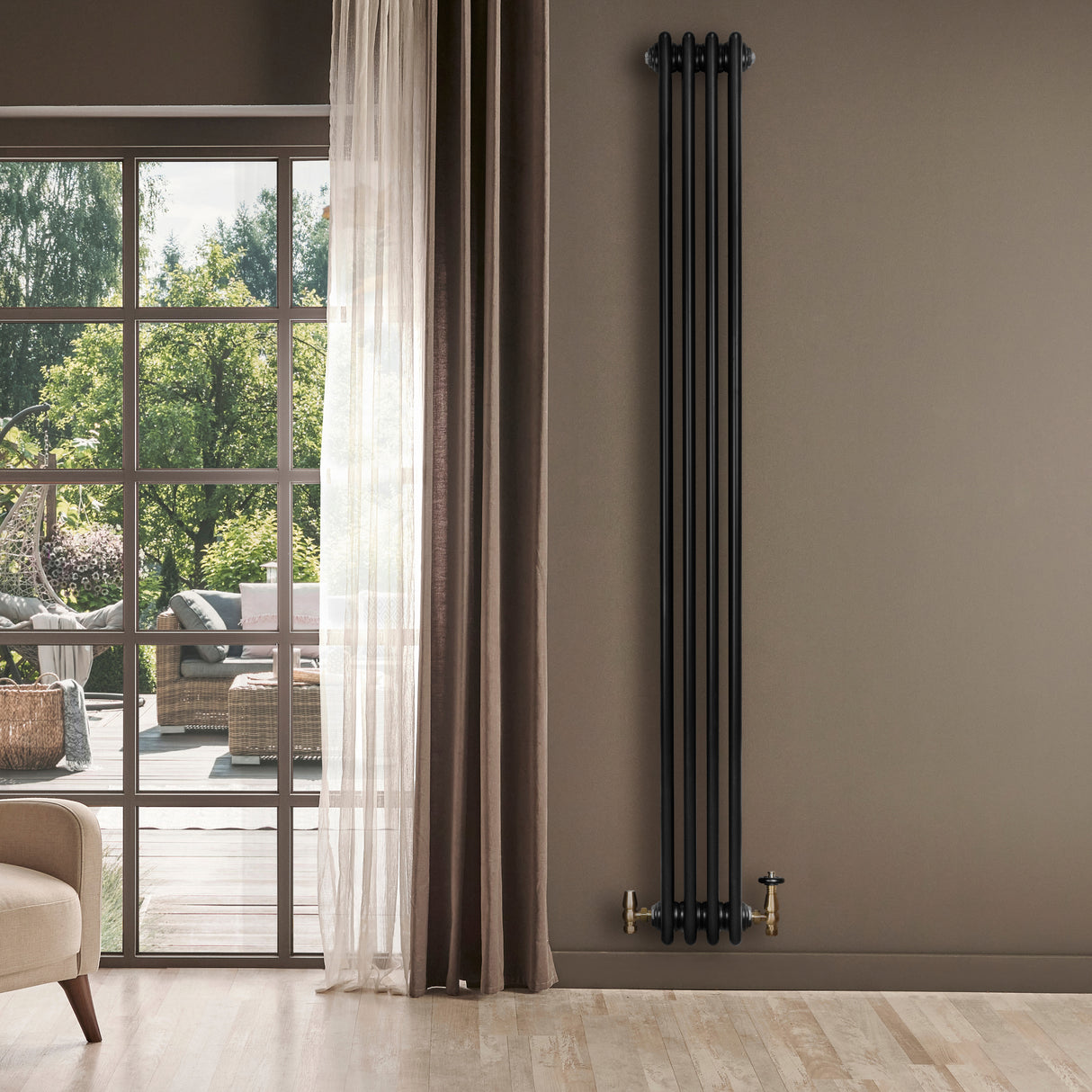 Radiatore tradizionale verticale a 4 colonne, finitura nera lucida, con valvole dorate, installato in un ambiente moderno e luminoso
