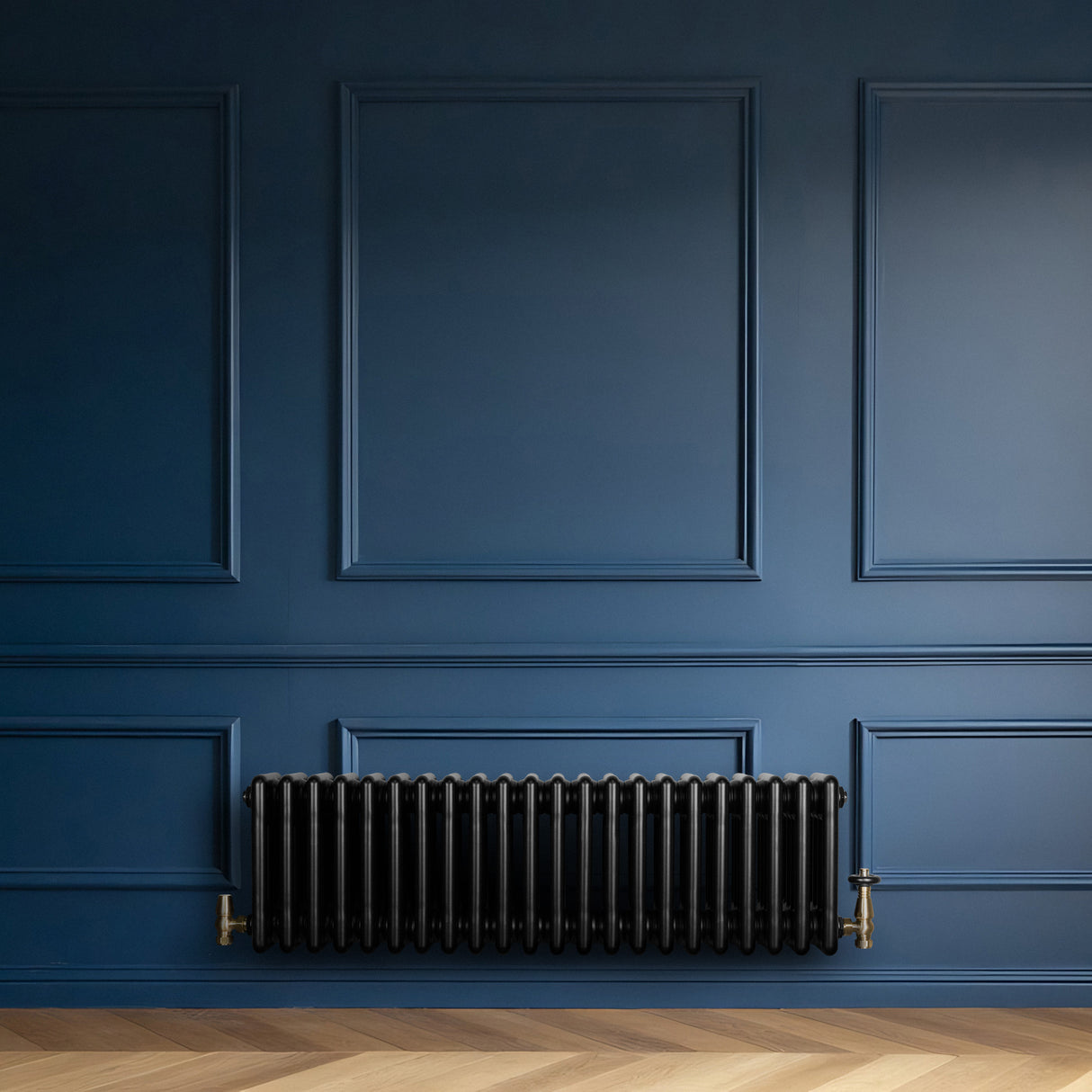 Radiatore tradizionale a 4 colonne, 300 x 1010 mm, finitura nera lucida, installato su parete blu, con dettagli in ottone