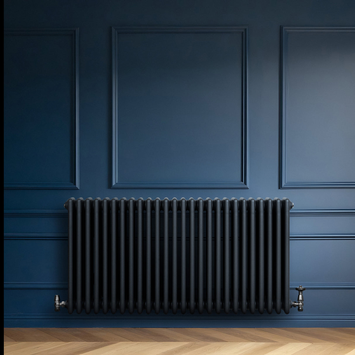 Radiatore tradizionale a 4 colonne orizzontali, colore antracite, con finitura liscia, montato su parete blu scuro, elegante e moderno