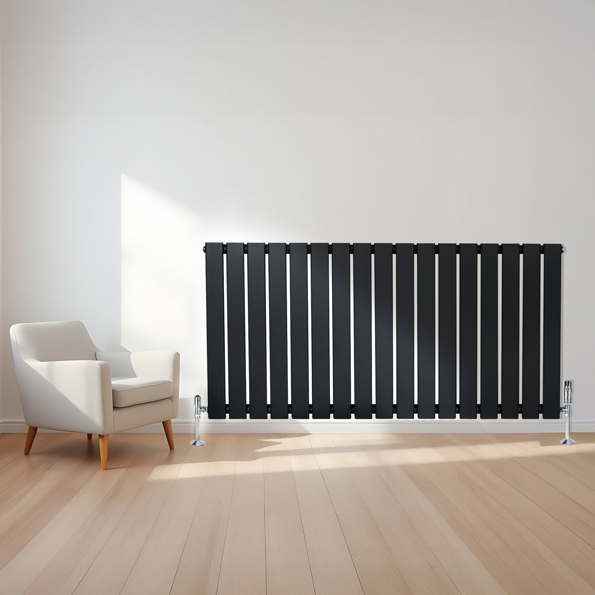 Radiatore piatto a colonna singola orizzontale nero, con finitura liscia e linee moderne, posizionato accanto a una poltrona bianca su pavimento in legno chiaro