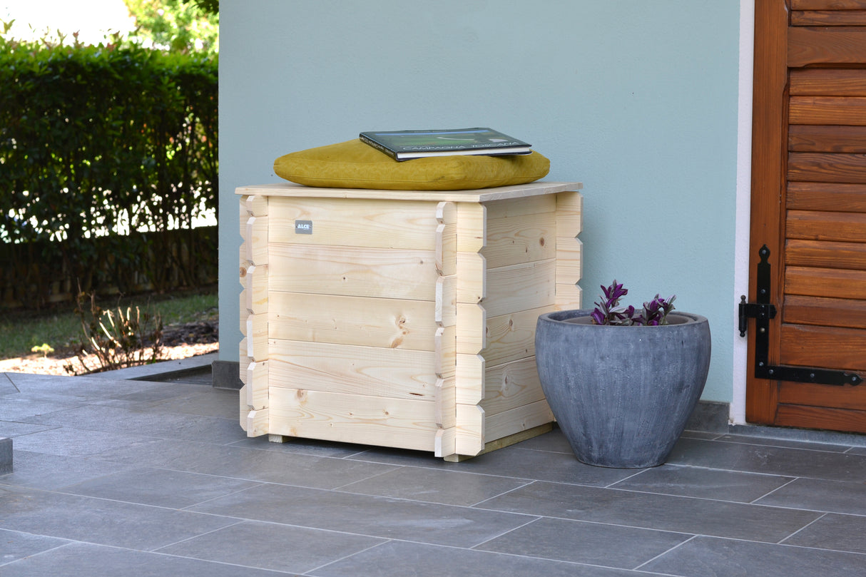 Cassapanca Gaia in legno chiaro, dimensioni 60x60xh56 cm, con cuscino giallo sopra e vaso grigio accanto, ideale per esterni