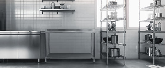 Cucina moderna con armadi in acciaio inox, ripiani metallici e pentole in acciaio, illuminata da finestre ampie e luminose