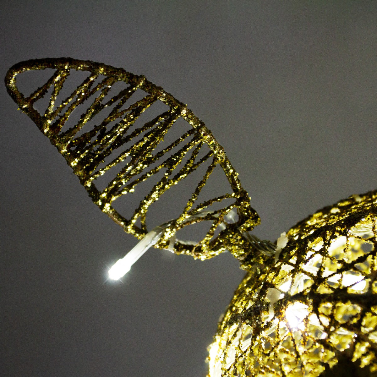 Renna di Natale luminosa in oro con dettagli intrecciati, orecchie a forma di foglia e luci brillanti per un'atmosfera festiva
