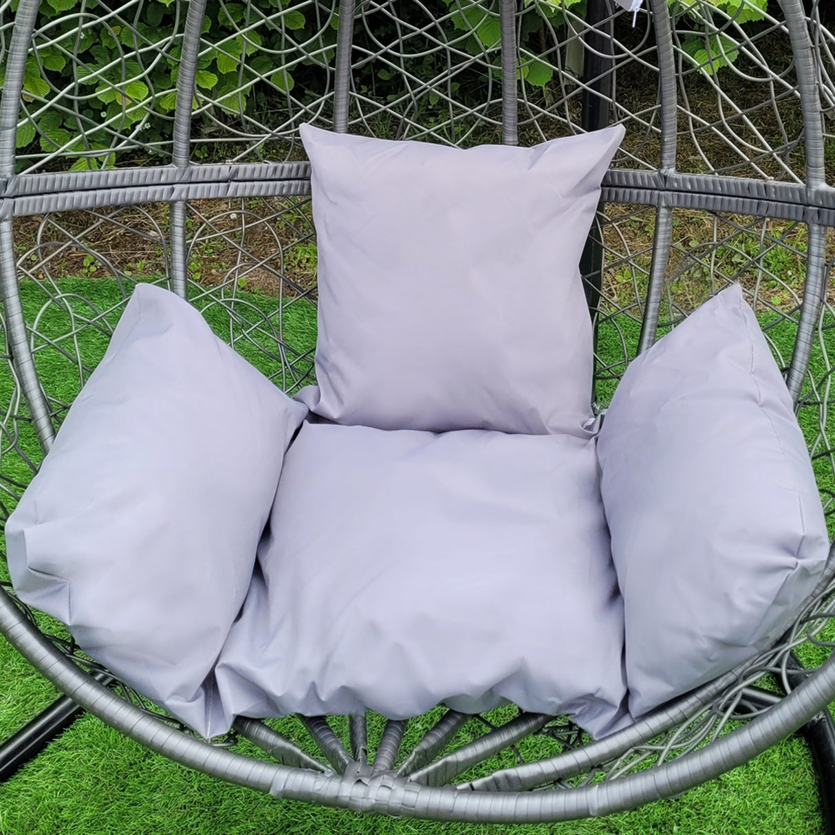 Sedia sospesa a uovo da giardino in rattan grigio, con cuscini morbidi e accoglienti, perfetta per il relax all'aperto