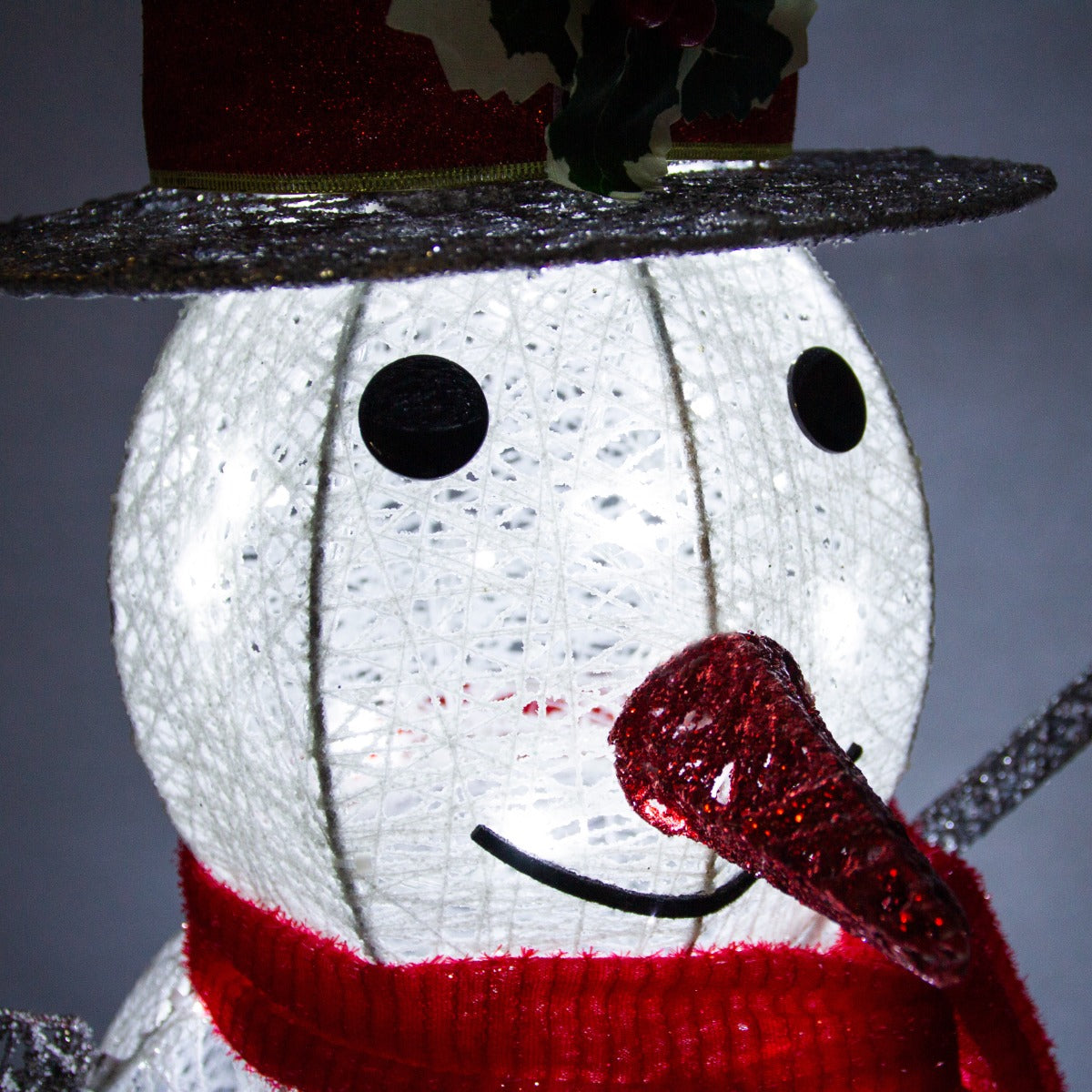 Pupazzo di neve luminoso con cappello rosso, sciarpa rossa e naso a forma di carota, realizzato in materiale traslucido e decorativo
