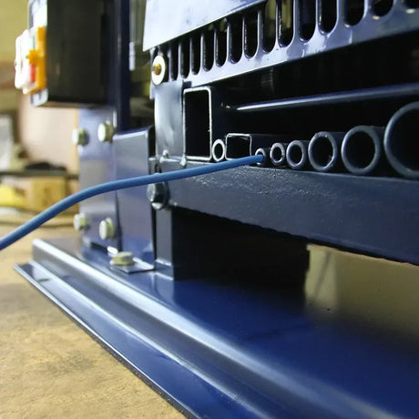 Dettaglio della spellafili T-Mech, con struttura blu, tubi di plastica e cavi, evidenziando la precisione e i materiali robusti