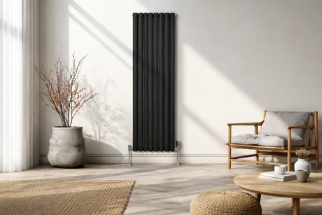 Radiatore a colonne nero elegante in un soggiorno moderno, accanto a una pianta in vaso e un comodo divano in legno chiaro
