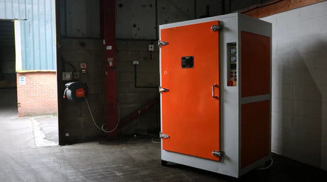 Forno di cottura termoindurente arancione e bianco, con maniglie metalliche e pannelli isolanti, situato in un ambiente industriale
