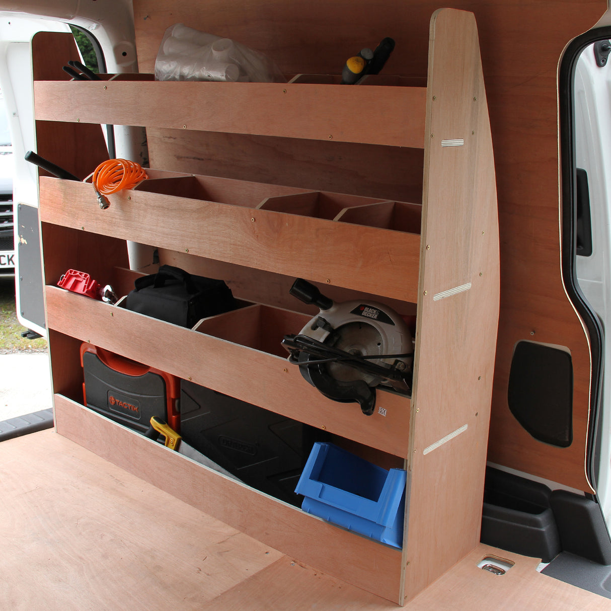 Rivestimento grigio fumo per furgone con scaffalatura in legno, dotato di scomparti per attrezzi e materiali, ideale per VW Caddy