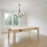 Tavolo multigioco 7-in-1 beige effetto legno, con struttura in legno chiaro e maniglie nere, in una stanza luminosa e moderna