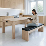 Tavolo multigioco beige in legno con panca contenitore, superficie liscia e moderna, utilizzato da una giovane donna che legge in cucina