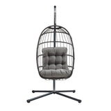 Poltrona sospesa a uovo in rattan nero, con struttura metallica e cuscino grigio imbottito, design moderno e accogliente