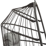 Poltrona sospesa a uovo in rattan nero, con struttura robusta e dettagli intrecciati, perfetta per interni ed esterni eleganti