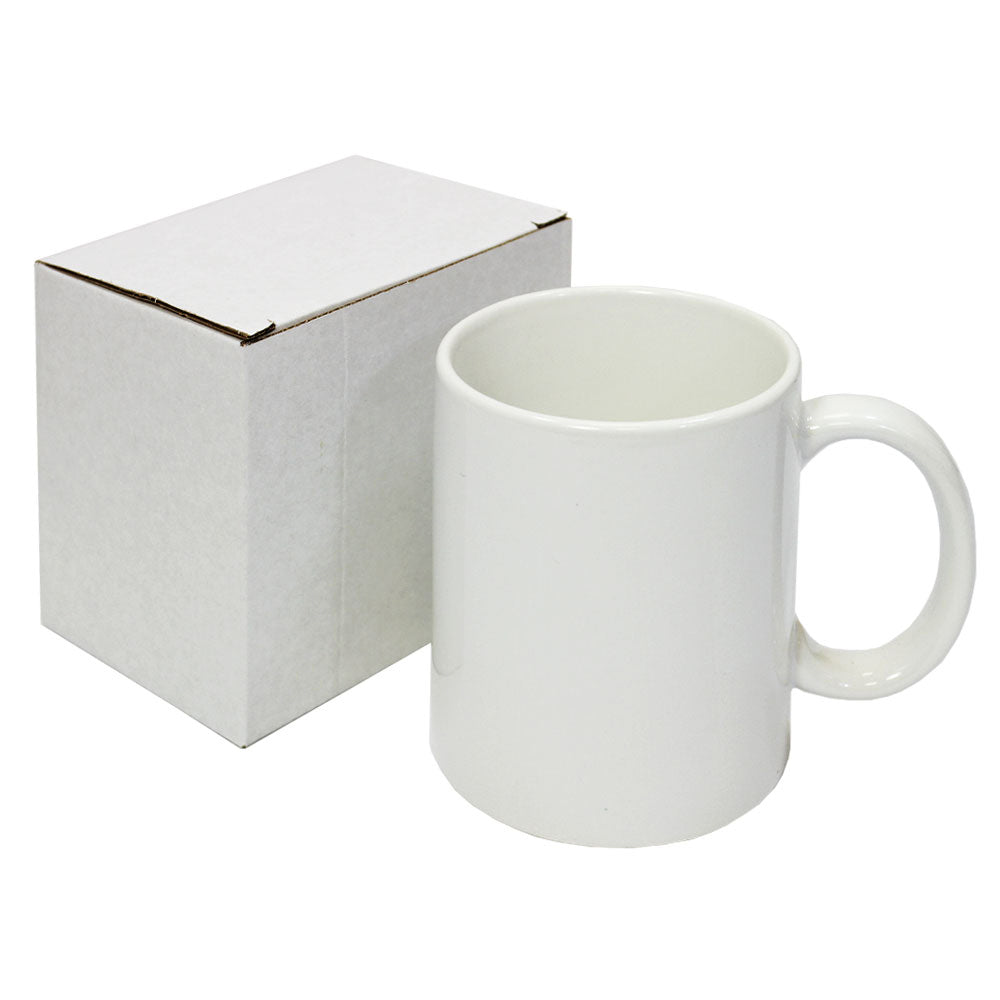 Tazza in ceramica bianca per sublimazione, con manico rotondo, accanto a una scatola bianca, ideale per personalizzazioni creative