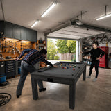 Tavolo giochi 7-in-1 grigio con superficie liscia, freccette e luci LED, utilizzato da due persone in un garage ben attrezzato