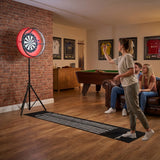 Tavolo giochi grigio 7-in-1 con freccette, luce LED rossa, pavimento in legno e persone che si divertono in un ambiente accogliente