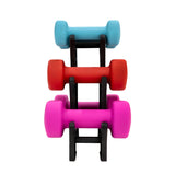 Manubri colorati in gomma: blu, rosso, rosa, impilati su un supporto nero, ideali per allenamenti di forza e fitness