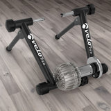 Rullo Fluido Velo Pro Nero con struttura nera e motore argentato, progettato per allenamenti indoor su pavimento in legno chiaro
