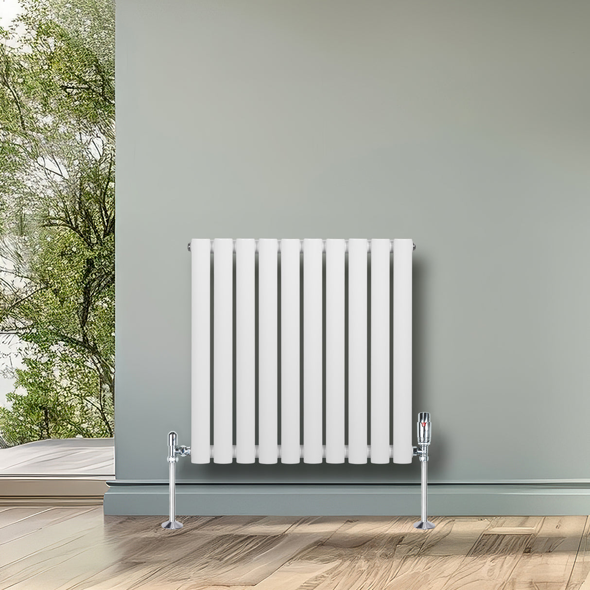 Radiatore ovale a colonna singola orizzontale bianco, con valvole, installato su parete grigia, in ambiente luminoso e naturale