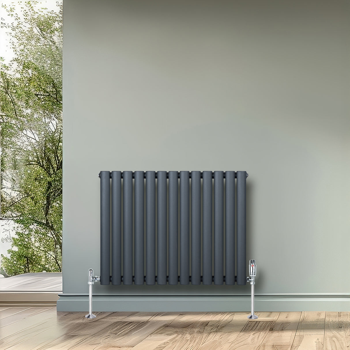 Radiatore ovale a colonna singola orizzontale antracite, con finitura liscia e valvole, posizionato su una parete verde chiaro