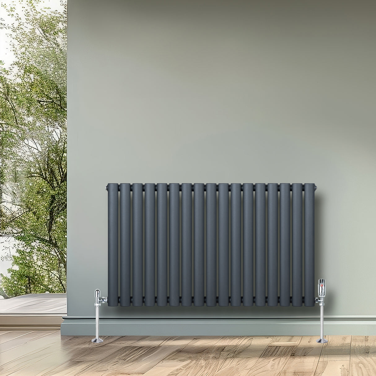 Radiatore ovale a colonna singola orizzontale antracite, con finitura liscia e valvole, posizionato su un pavimento in legno chiaro