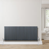 Radiatore ovale a colonna singola orizzontale antracite, con finitura liscia, posizionato su una parete chiara in un ambiente moderno e luminoso