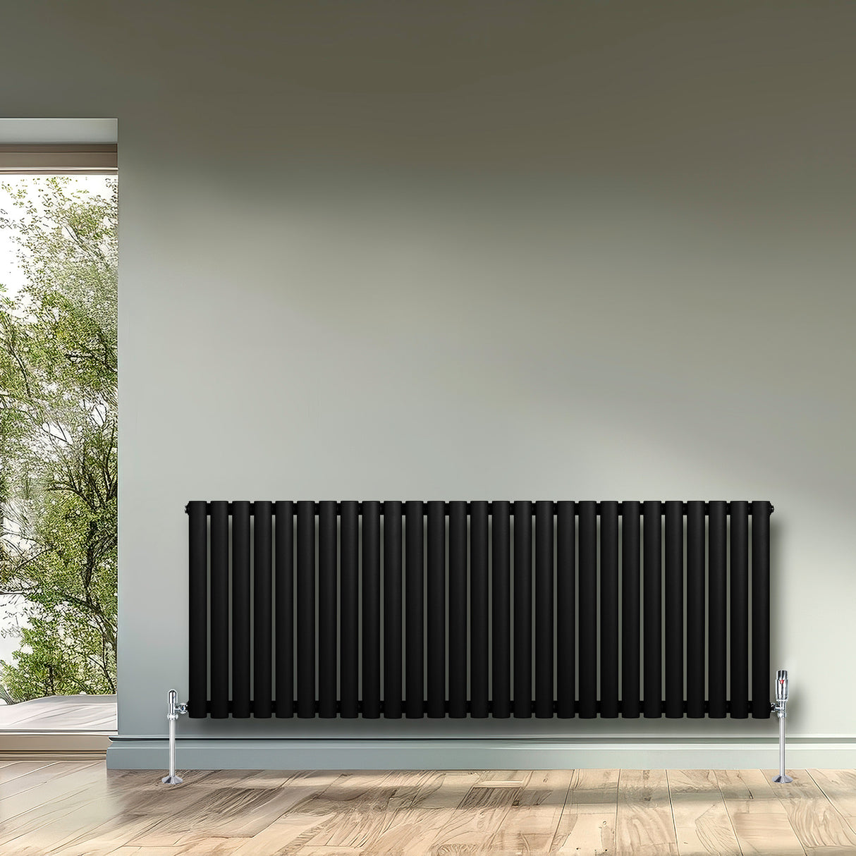 Radiatore ovale a colonna singola orizzontale, 600 x 1620 mm, colore nero opaco, con valvole, posizionato su parete chiara e pavimento in legno chiaro