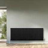 Radiatore ovale a colonna singola orizzontale, 600 x 1620 mm, colore nero opaco, con valvole, posizionato su parete chiara e pavimento in legno chiaro