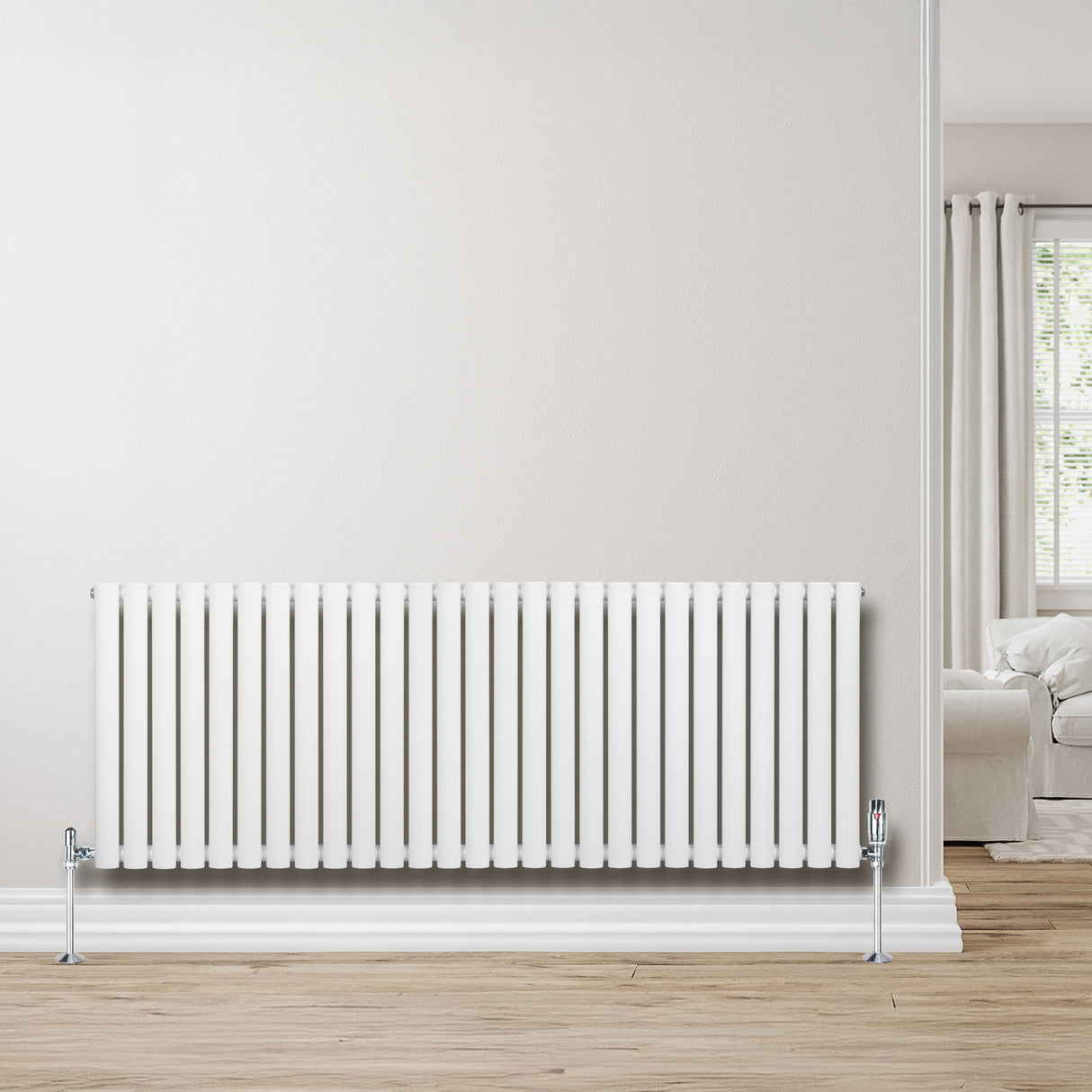 Radiatore ovale a colonna singola orizzontale bianco, con finitura liscia e valvole, posizionato su un pavimento in legno chiaro