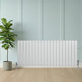 Radiatore piatto monocolonna bianco, 600 x 1400 mm, con finitura liscia e valvole, posizionato accanto a una pianta in vaso