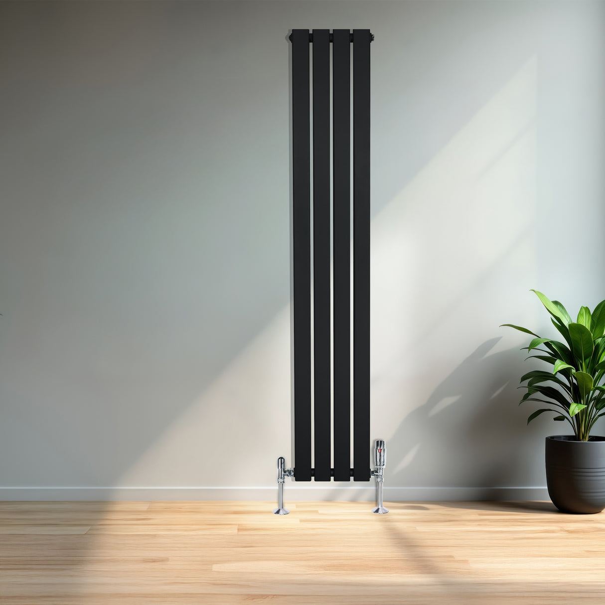 Radiatore piatto monocolonna nero, 1600 x 280 mm, con finitura liscia e valvole cromate, posizionato in un ambiente moderno con piante verdi