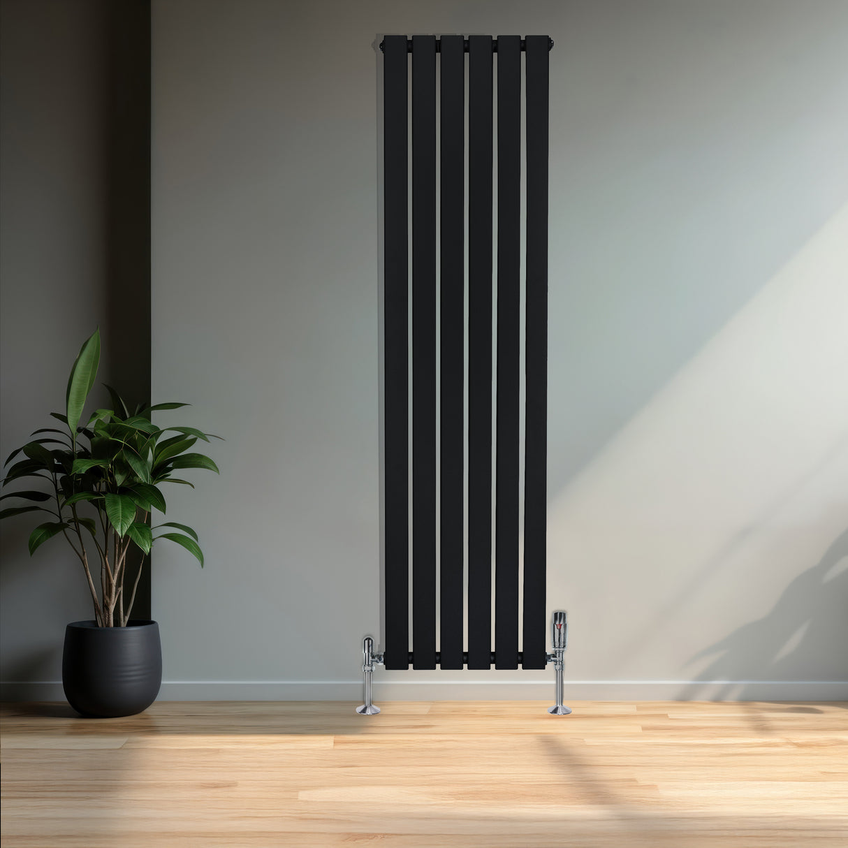 Radiatore piatto monocolonna nero, 1600 x 420 mm, con finitura liscia e valvole cromate, posizionato in un ambiente moderno con piante verdi