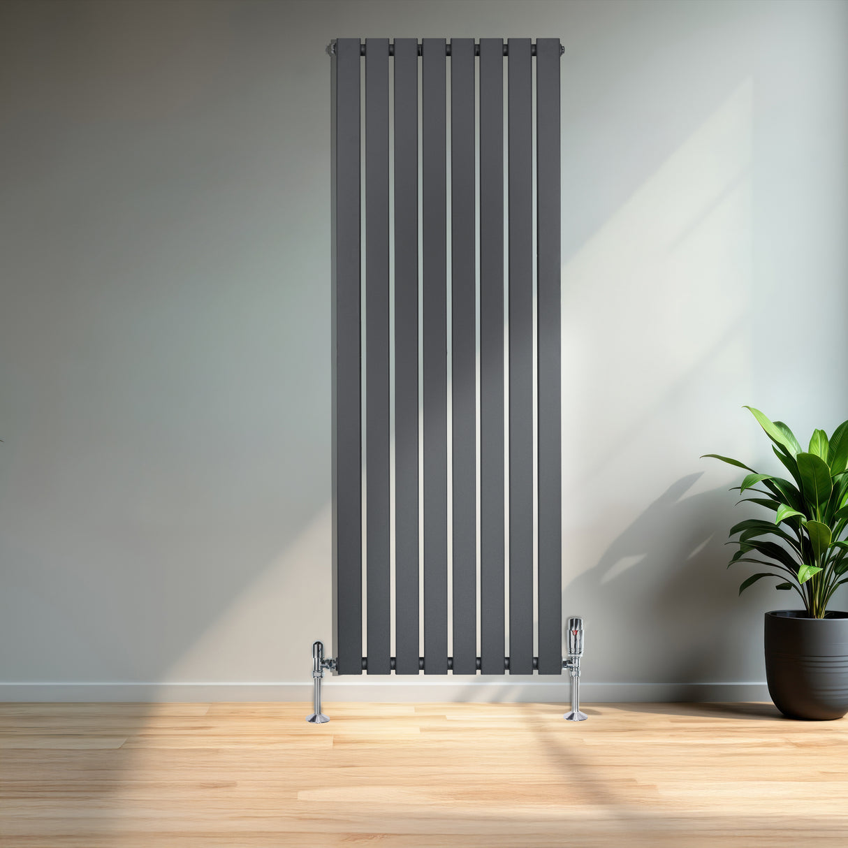 Radiatore piatto monocolonna grigio antracite, design elegante con finitura liscia, posizionato in un ambiente moderno con pianta decorativa