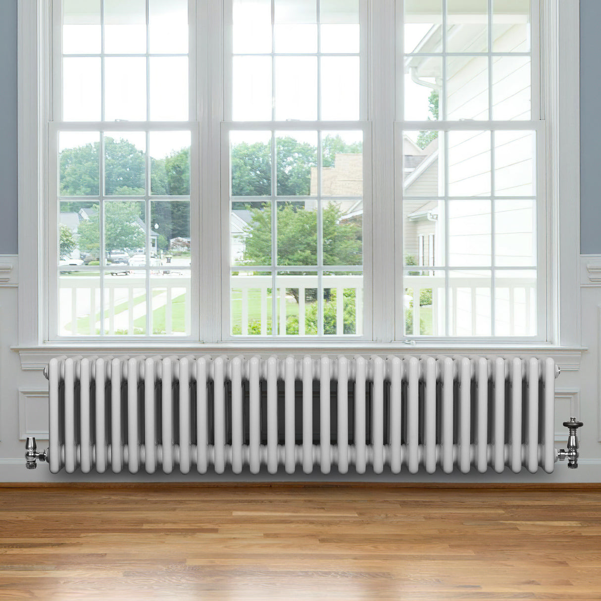 Radiatore tradizionale a 4 colonne, bianco lucido, lungo 1370 mm, posizionato sotto una grande finestra con vista esterna