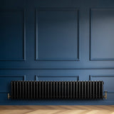 Radiatore tradizionale a 4 colonne, 300 x 1505 mm, colore nero lucido, installato su parete blu con dettagli eleganti e texture liscia