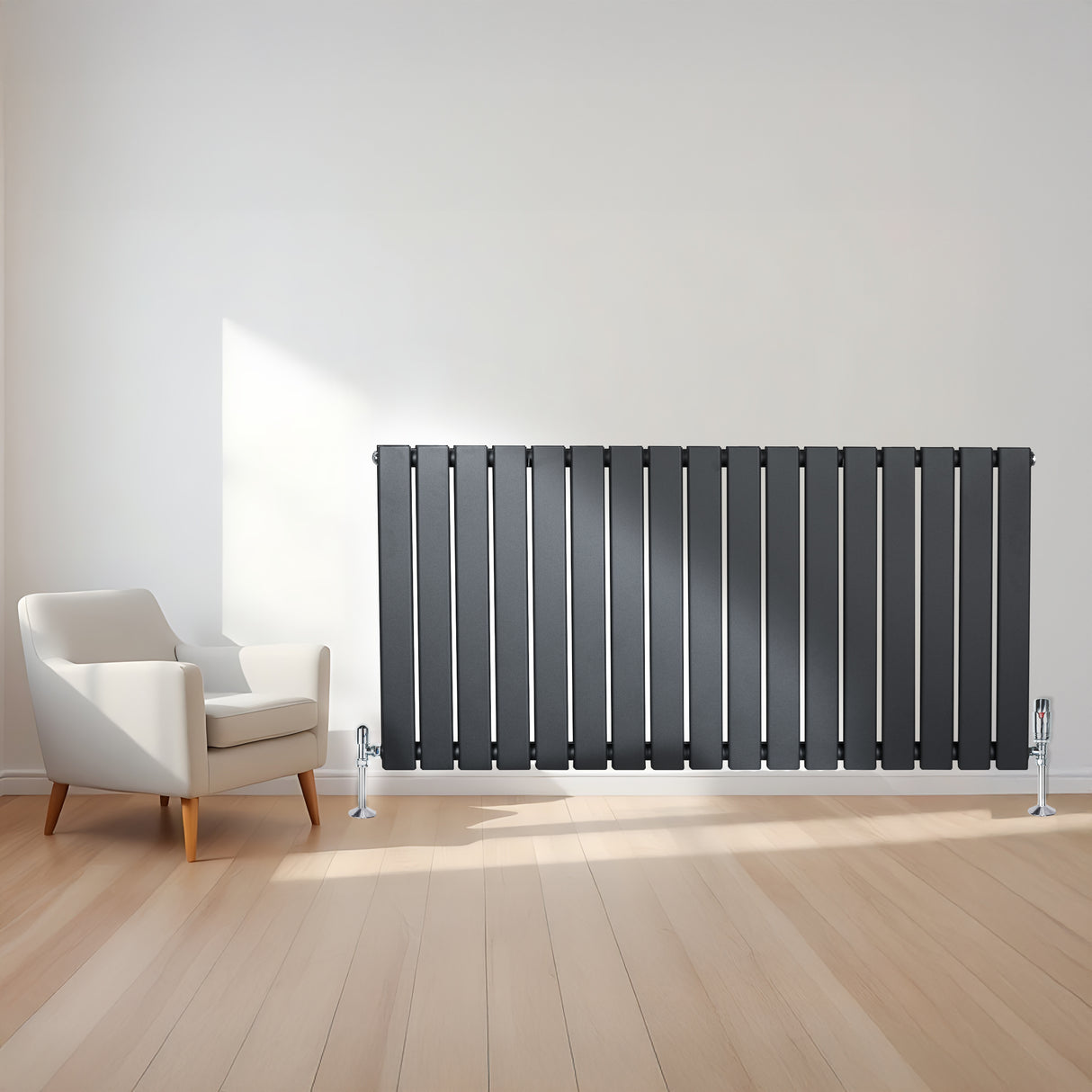 Radiatore piatto a colonna singola orizzontale antracite, con finitura liscia e linee moderne, posizionato accanto a una poltrona bianca su pavimento in legno chiaro