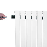 Radiatore piatto a colonna singola verticale bianco, con finitura liscia e pulita, mentre viene pulito con una spazzola nera