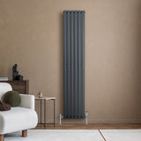 Radiatore ovale a colonna singola verticale antracite, 1800 x 360 mm, con finitura liscia e design moderno, posizionato su parete beige