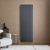 Radiatore ovale a colonna singola verticale antracite, 1800 x 600 mm, con finitura liscia e design moderno, posizionato su parete beige