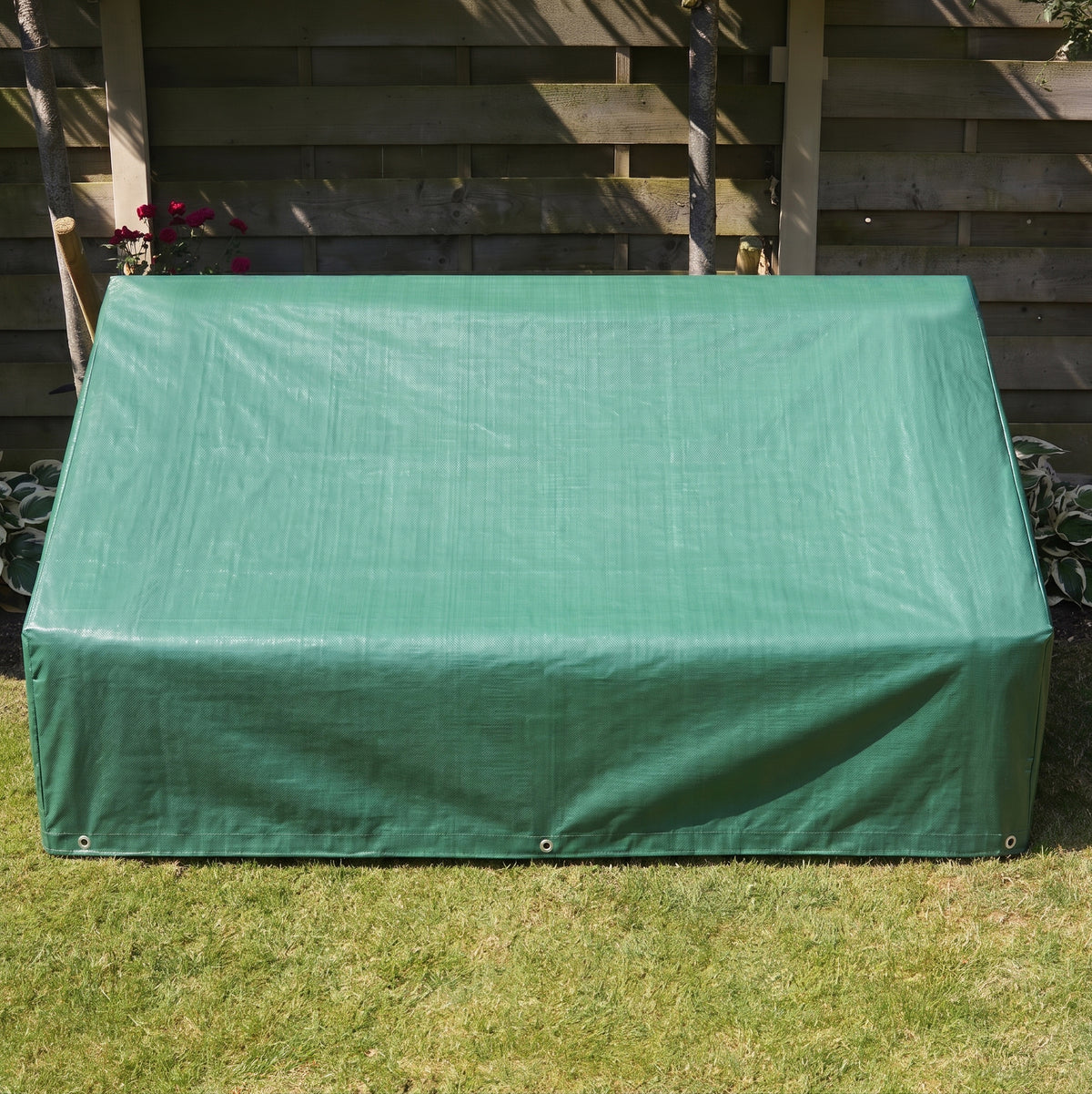 Copertura verde in tessuto resistente per mobili da giardino, con superficie liscia e angoli rinforzati, posizionata su prato verde