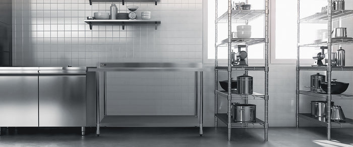 Cucina moderna con armadi in acciaio inox, ripiani metallici e pentole in acciaio, illuminata da finestre ampie e luminose
