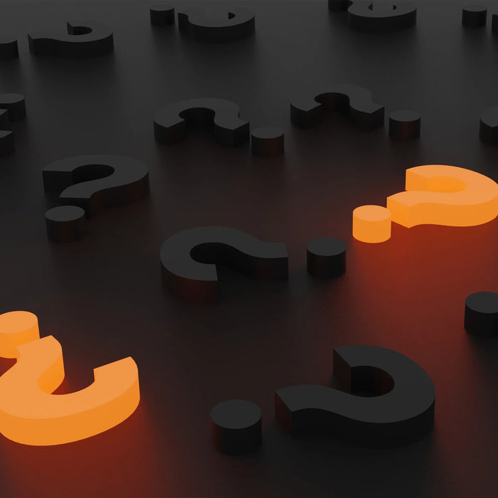 Simboli di punto interrogativo in nero e arancione su sfondo scuro, creando un contrasto visivo intrigante e moderno